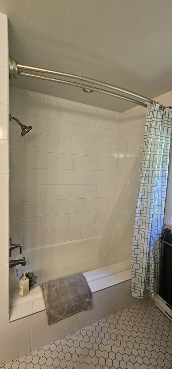 Bathroom renovation — marble tile surround, tub and shower combo · Salt Spring Island