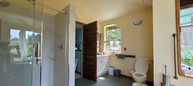 Bathroom renovation — marble tile shower, frameless glass enclosure · Salt Spring Island