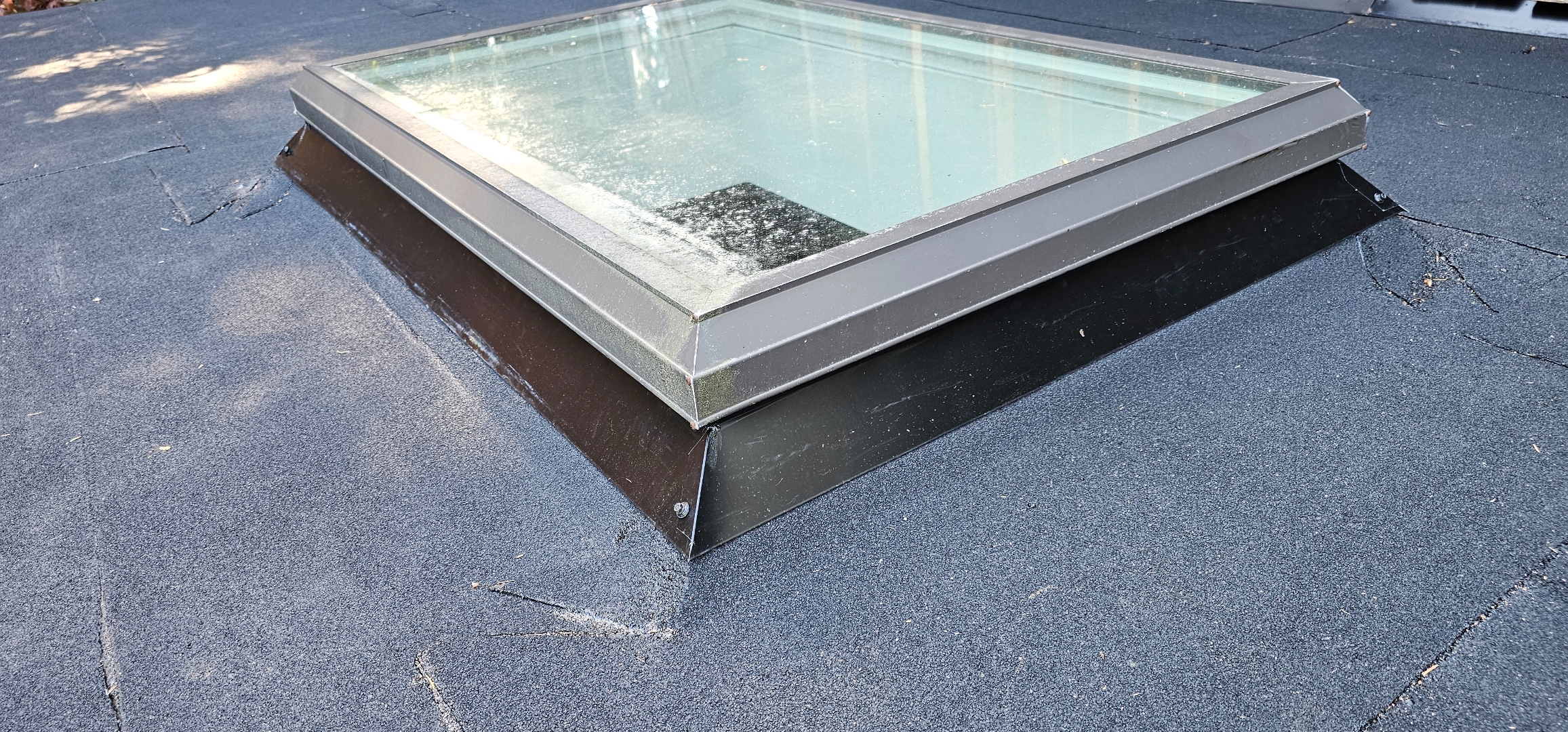 Flat roof skylight detail — clean aluminum frame, membrane tie-in, finished seams